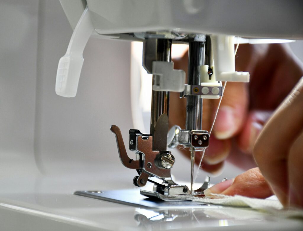 Machinist at a sewing machine (placeholder, Unsplash / Omar Alrawi)