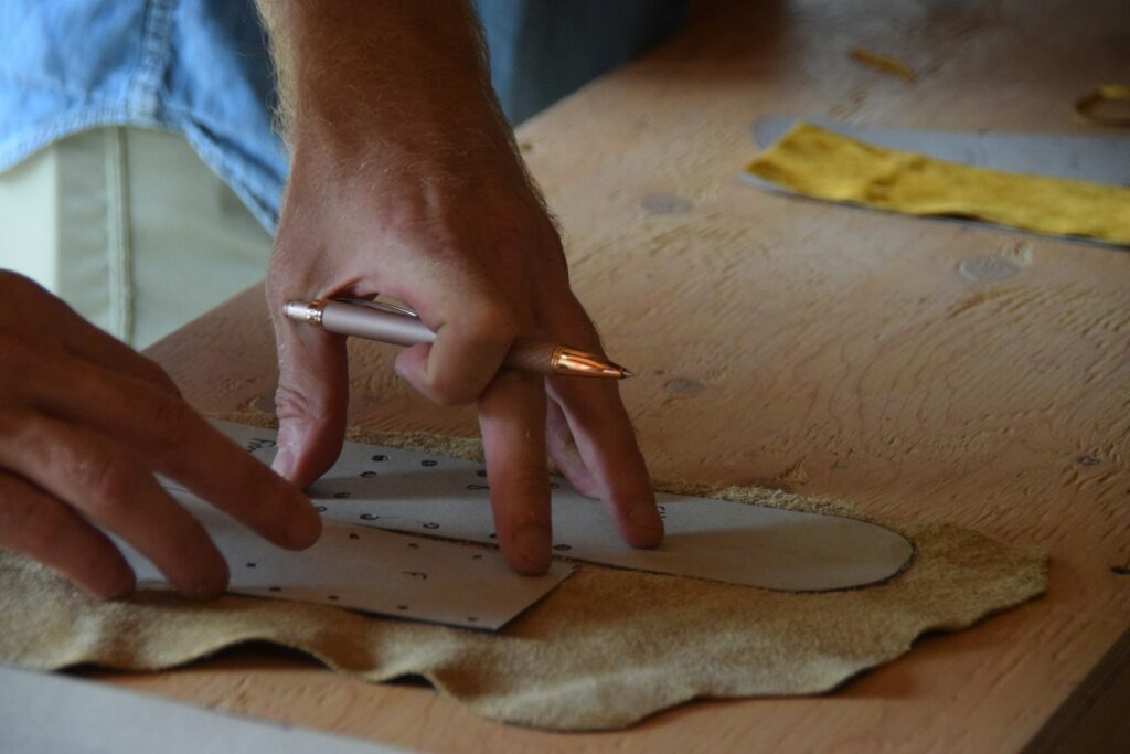 Tracing a pattern onto tan leather (placeholder, Unsplash / Cohen Berg)